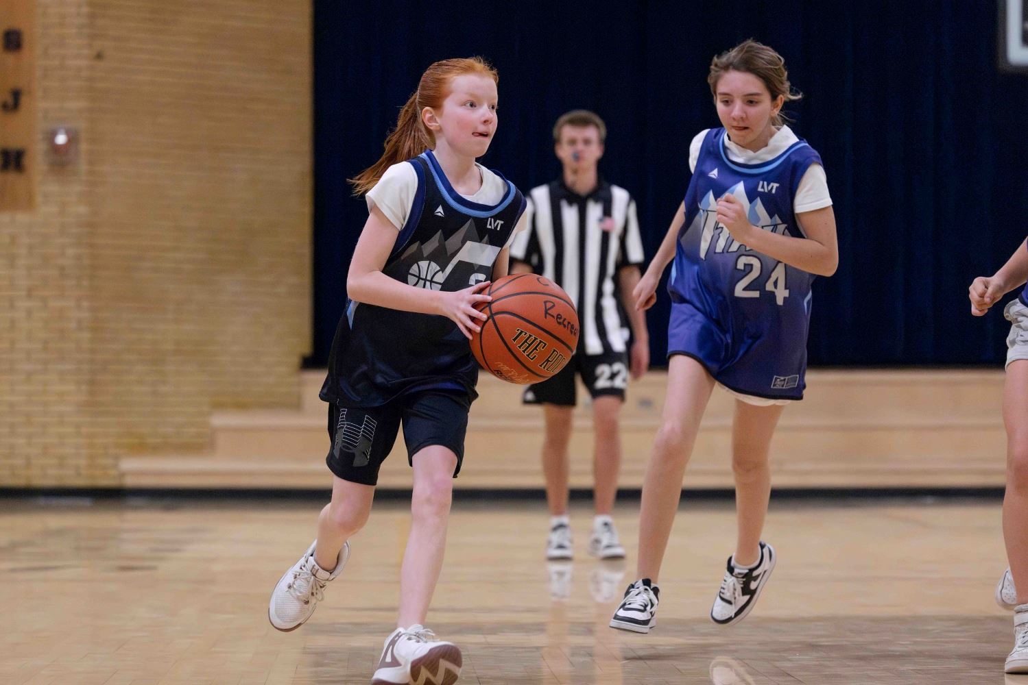 a girl dribbling a basketbal